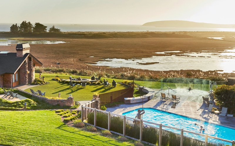View Of Grass Sitting Area, Pool And Spa With The Saltmarsh And Ocean In The Background.