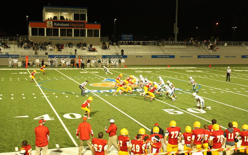 Football Game At Night With Teams Playing On The Field