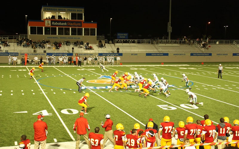 Football game at night with teams playing on the field